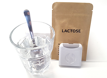 AIRE digestive tracker with a lactose sachet and glass.