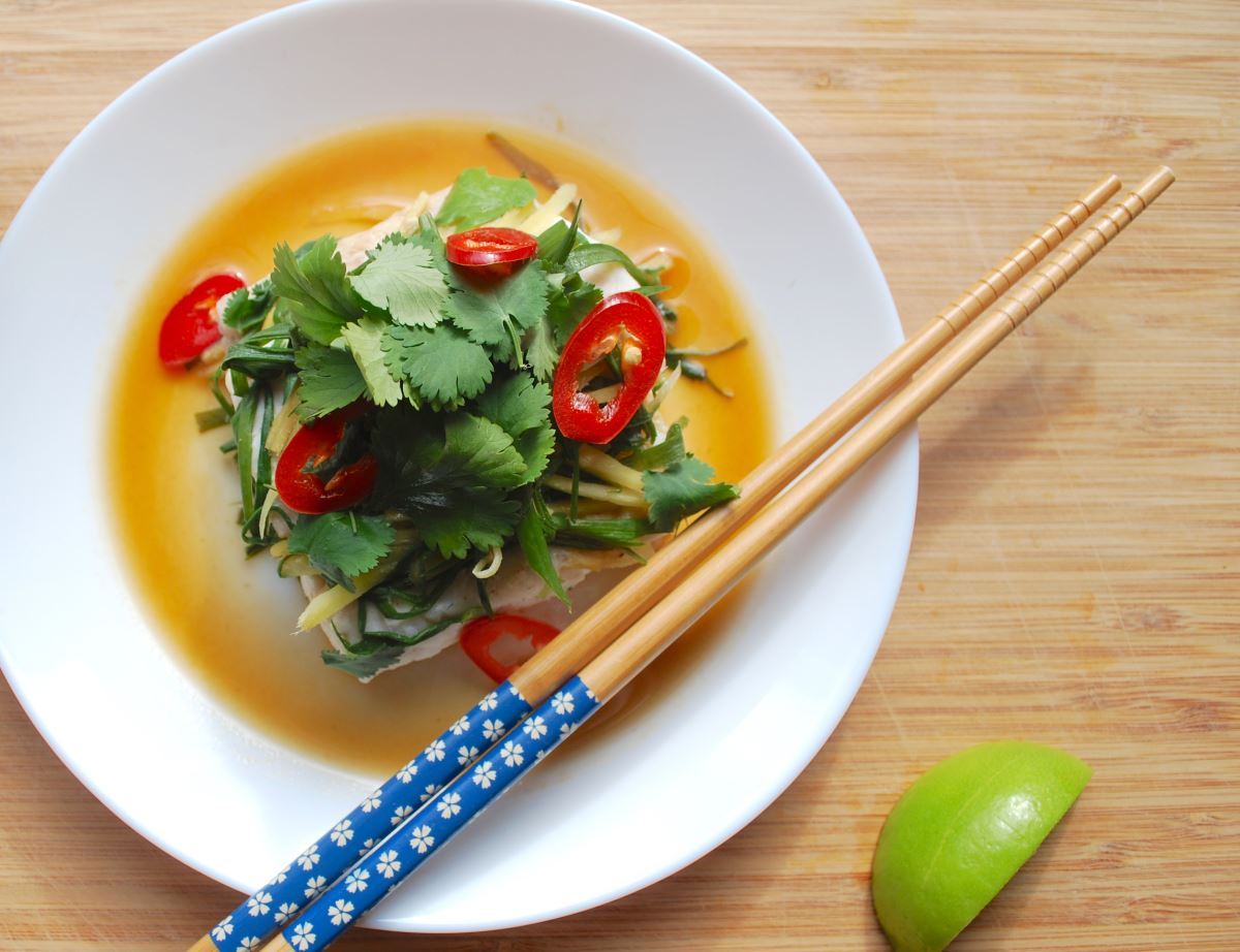 steamed fish and rice with chopsticks and a lime wedge