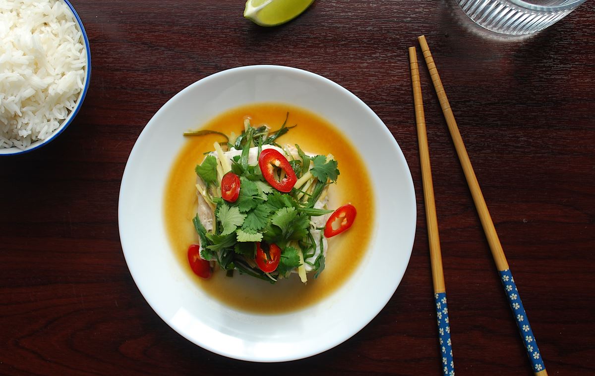 steamed fish and rice with chopstick on dark background