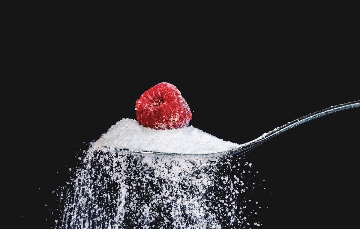 Raspberry and sugar on spoon with black background
