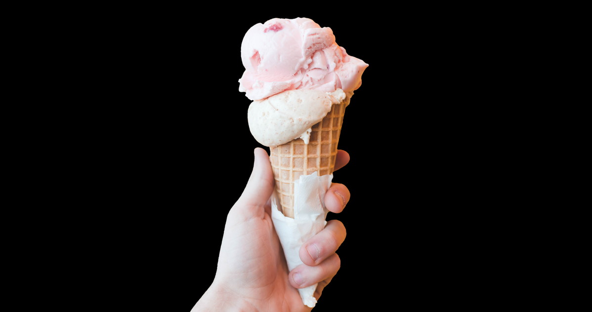 hand holding ice cream cone on black background