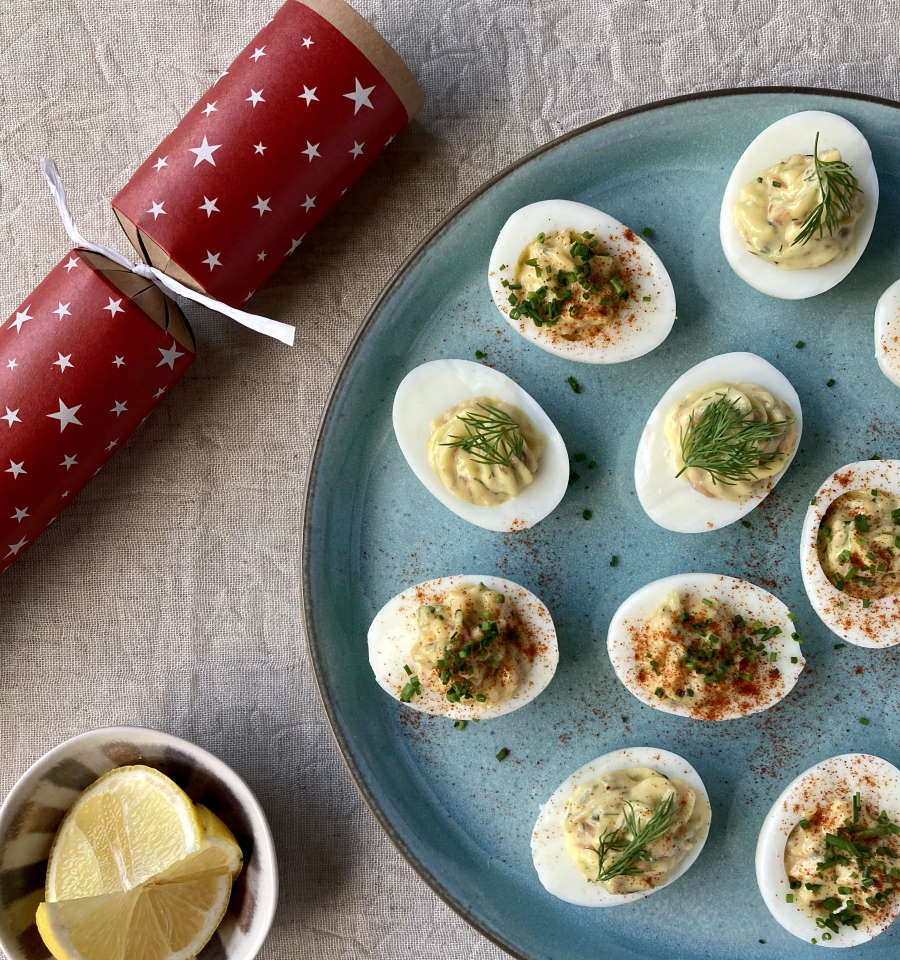 deviled eggs on blue plate with red and white christmas cracker